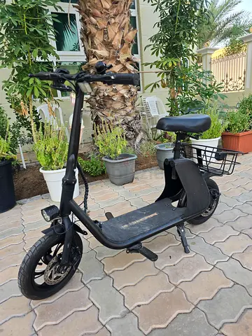 Electric seated scooter with front light and rear basket - good condition