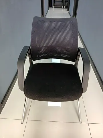 Black mesh office visitor chair with armrests — good condition