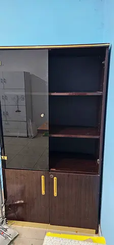 Dark wood storage cabinet with shelves and lockable doors AED25