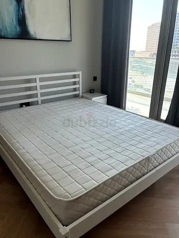 White wooden double bed with mattress