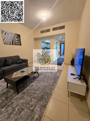 A beautiful one-bedroom apartment with a living room and high-end (VIP) furnishings in Ajman Towers 1. It features two bathrooms, a balcony, and parki