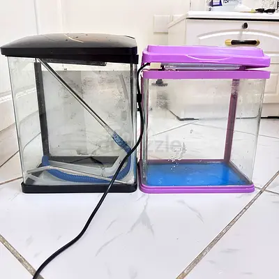 Two small used fish aquariums with lids and accessories
