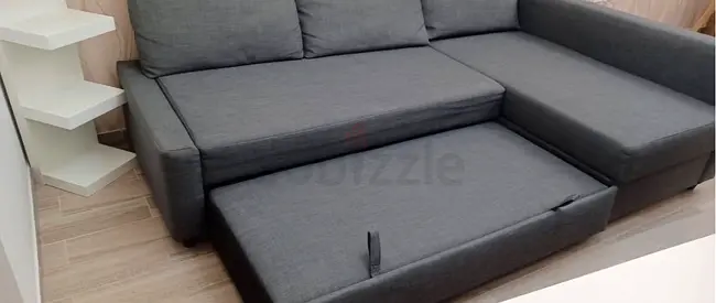 Grey L-shaped sofa bed with pull-out bed — good condition