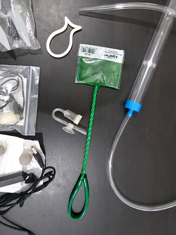 Assorted aquarium accessories — siphon, fish net, shrimp net, mineral balls, motor, mini heater