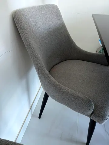 Grey upholstered dining/desk chair with black legs - good condition