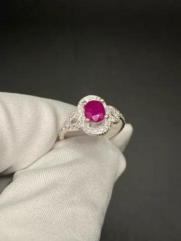 Silver ring with round ruby center and halo of small diamonds
