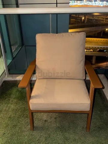 Single modern wooden frame lounge chair with beige cushions