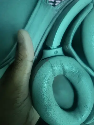 Used over-ear headphones with worn ear cushions, broken hinge swivels and 14 pin connector cable