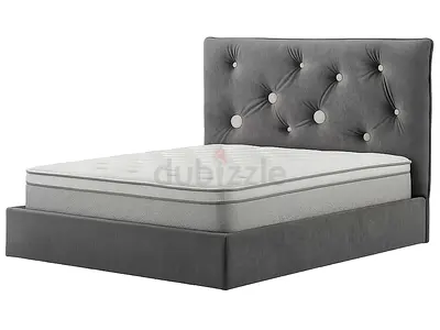 Grey upholstered double bed with tufted headboard