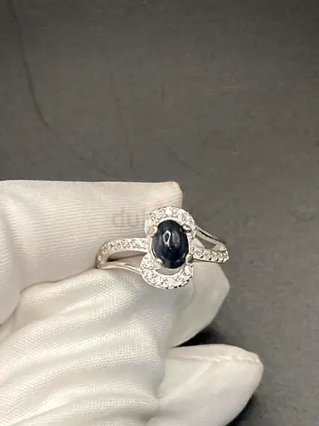 Silver ring with dark oval cabochon center and pavé accents