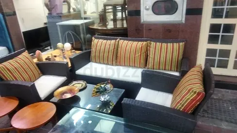 Rattan outdoor sofa set with glass coffee table and cushions - good condition