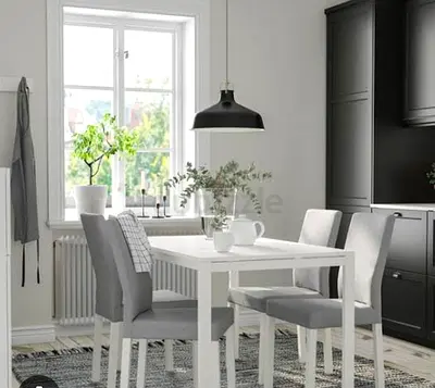 Simple white dining table with four grey upholstered chairs