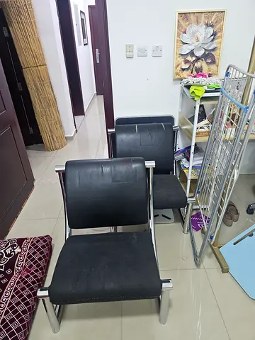 Pair of black leather dining chairs with metal frame 100 dhs each