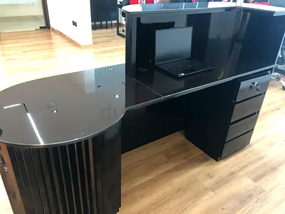 Black glossy reception desk with storage and raised counter