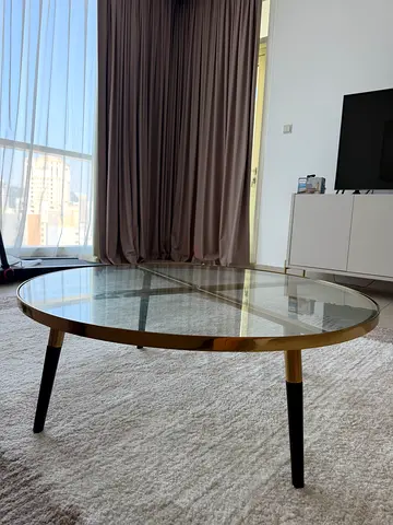 Round Glass Coffee Table with Brass Trim and Black Legs