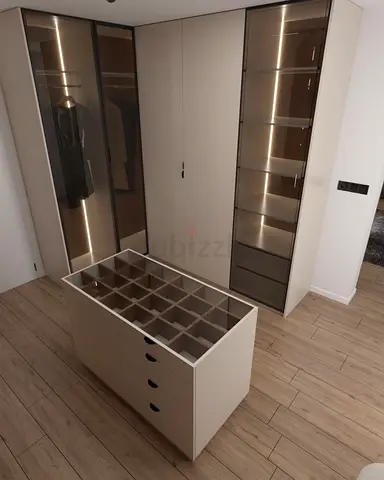 Modern walk-in wardrobe unit with island and glass display cabinets
