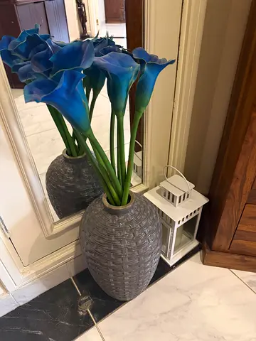Grey woven floor vase with artificial blue calla lilies