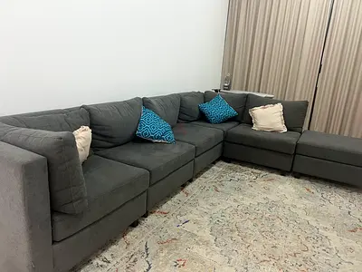 Large grey L-shaped sectional sofa with cushions