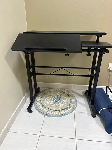Compact black computer desk with keyboard tray and wheels