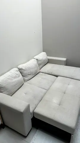 Light beige L-shaped fabric sofa with pull-out bed
