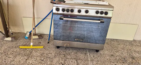 Used freestanding gas oven with 5 control knobs — good working condition with big heavy griller n ba