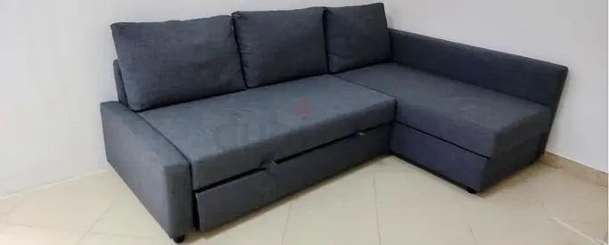 L-shaped grey fabric sofa bed with storage and pull-out bed - good condition