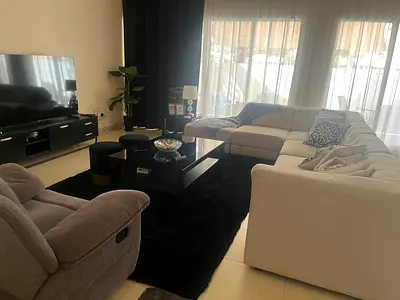 Large L-shaped Corner Sofa with Black Rug and Coffee Table - Good Condition