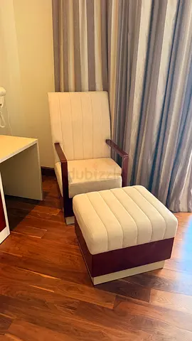 Beige upholstered armchair with matching ottoman - good condition