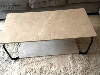Modern beige marble-look coffee table with lower shelf