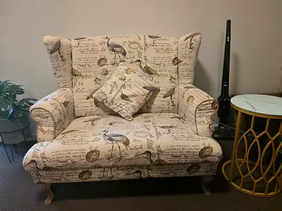Two-seater wingback sofa with bird print upholstery