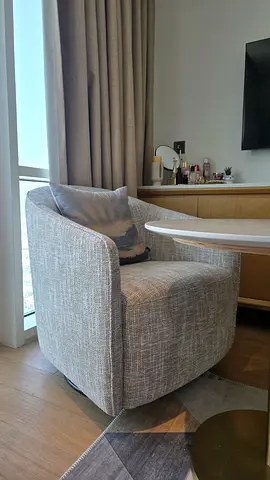 Light warm grey upholstered 360 revolving rocking chair