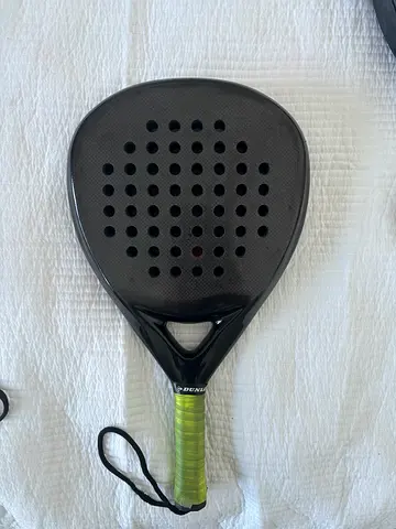Used black padel racket with green grip - good condition