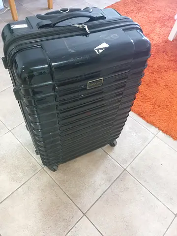 Large black hard-shell roller luggage suitcase with wheels