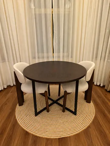 Round dark wood dining table with metal legs and 2 chairs