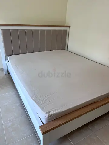 Double bed frame with upholstered headboard and wooden accents - good condition