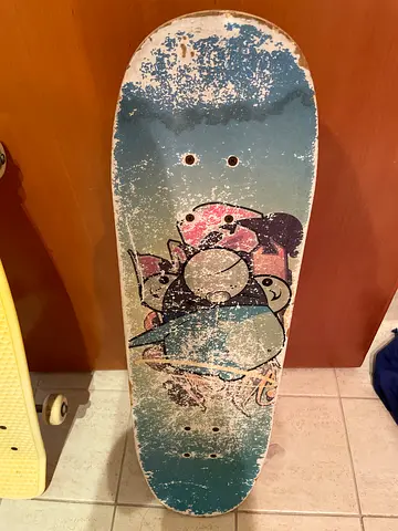 Used Wooden skateboard deck with worn graphic — vintage-style cruiser deck