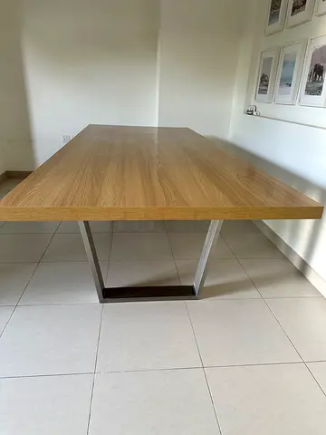Rectangular dining table featuring a natural oak-effect wood top and contemporary silver metal