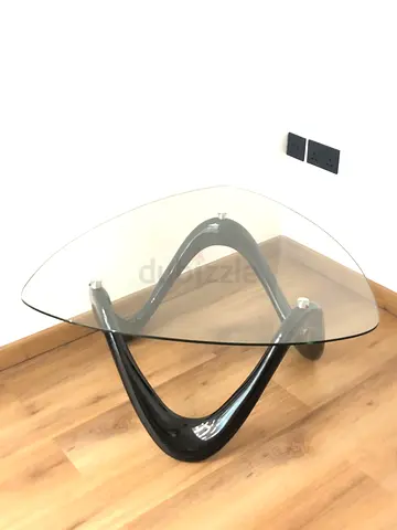 Modern triangular glass coffee table with black curved base