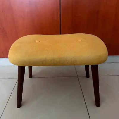 Upholstered yellow footstool