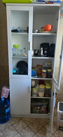 Tall white kitchen storage cabinet with glass doors