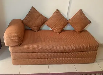 Orange single-arm chaise lounge sofa with cushions