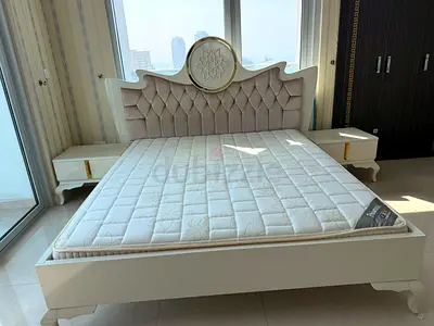 White ornate double bed frame with mattress and matching bedside tables