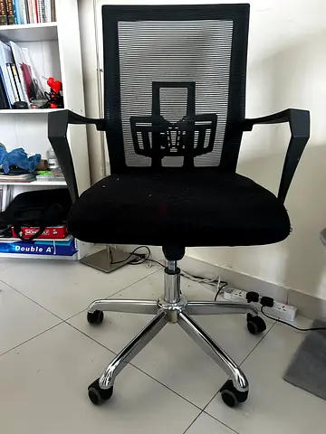 Black mesh office chair with adjustable height and armrests.