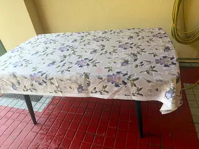 Used rectangular dining table with floral tablecloth - sturdy legs plus two chairs