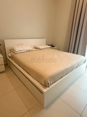 White wooden king bed frame with headboard  4 drawers in bottom and bedside tables good condition
