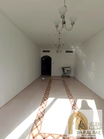 A two-bedroom and living room apartment is available for annual rent in the Al Taawun area of ​​Sharjah. It features a spacious layout, an open view,