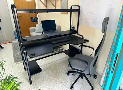 Black metal multi-level computer desk with monitor shelf and headphone hook