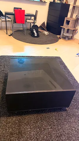 Black low-profile square coffee table with glass top
