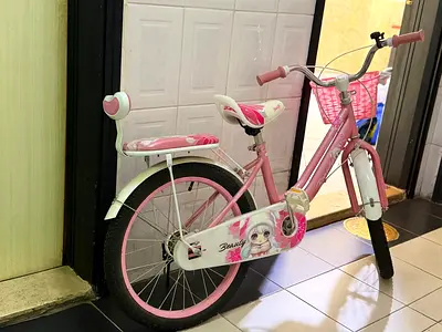 Pink kids' bicycle with training wheels and rear seat - good condition