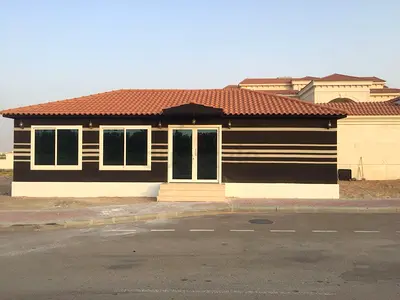 Small standalone garden room with tiled roof and large windows